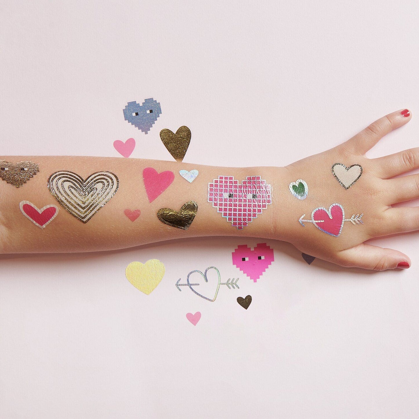 Kindearm mit aufgetragenem Herz-Tattoo in Gold-Optik.