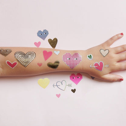 Kindearm mit aufgetragenem Herz-Tattoo in Gold-Optik.