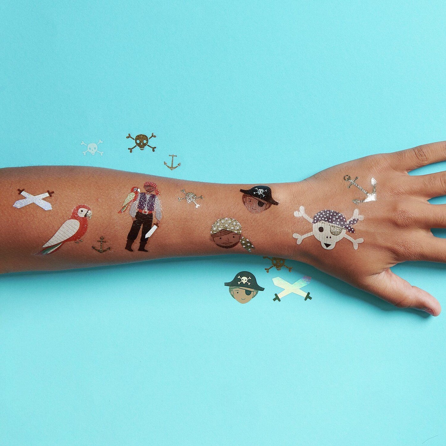 Leuchtendes Piraten-Tattoo auf dem Oberarm eines Kindes in einer dunklen Umgebung.